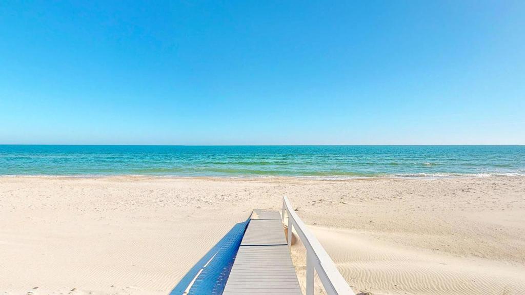 a wooden boardwalk leading to the ocean on a beach at Barefoot Bungalow in St. George Island