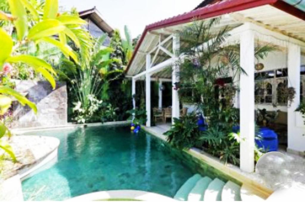 a swimming pool in front of a house at Blue Lagoon 5 bedrooms Villa in Kuta