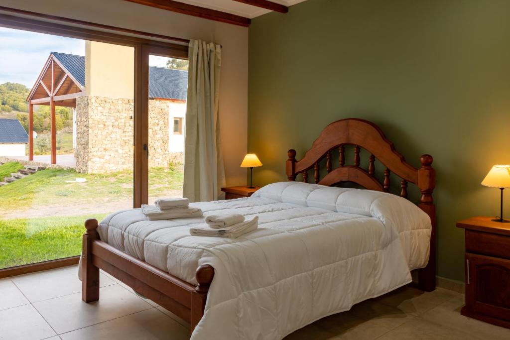 a bedroom with a bed and a large window at Cabañas La Catalana in Tandil