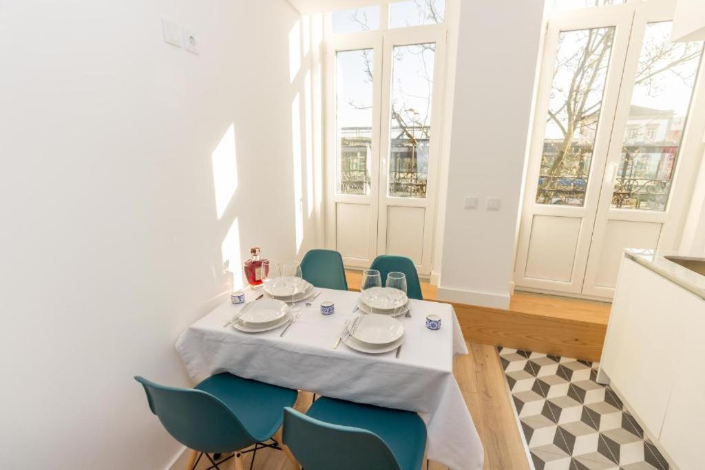 a dining room with a table and blue chairs at Oporto Modern Apartments - Campanha Train Station in Porto