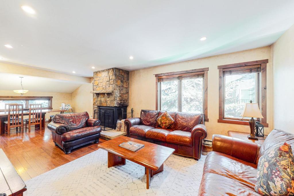 a living room with leather furniture and a fireplace at Larkspur Lodge in Avon