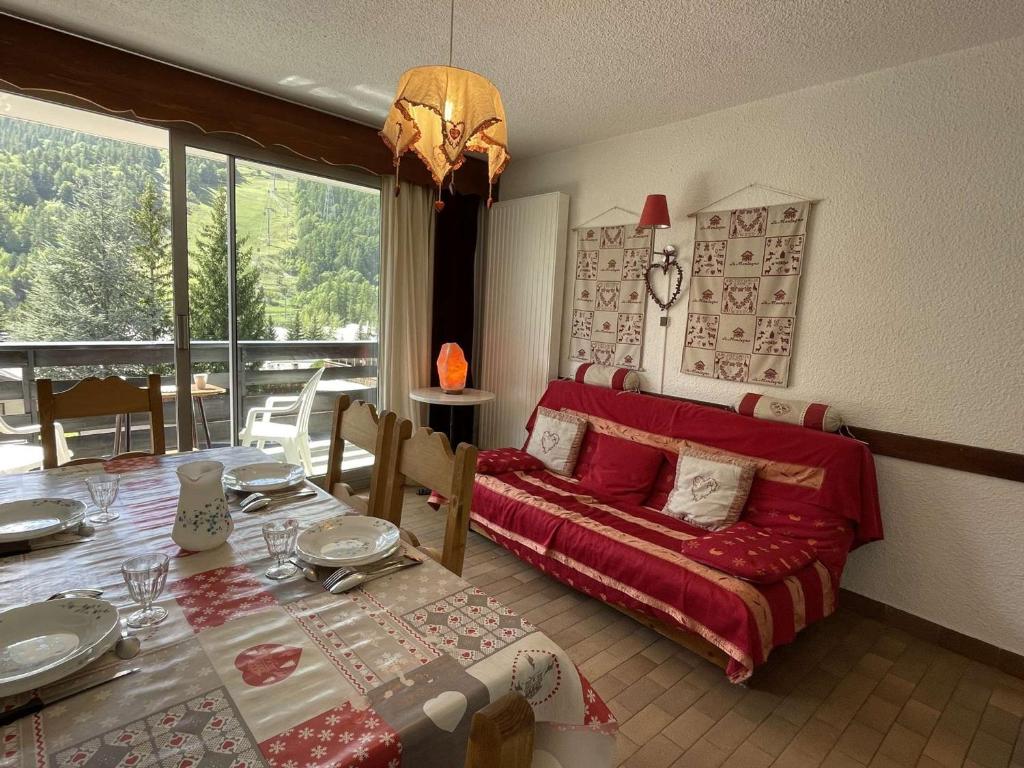 un salon avec un canapé rouge et une table dans l'établissement Studio cosy avec balcon, 4 pers., animaux admis - Serres-Chevalier - FR-1-330E-95, à Saint-Chaffrey