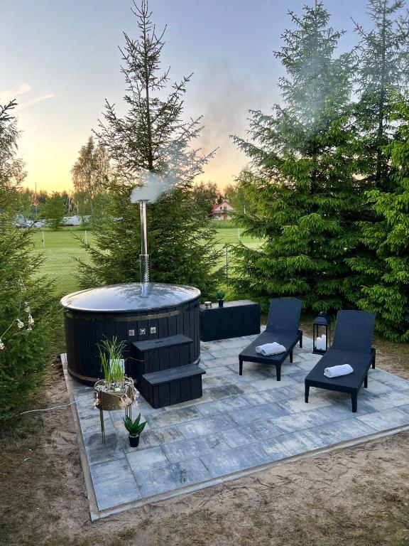 a fire pit with two chairs and a fountain at Domki Letniskowe Pola in Ryn