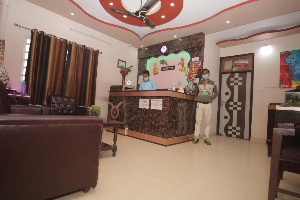 a man standing at a bar in a room at Hotel G M FORUM in Kānpur