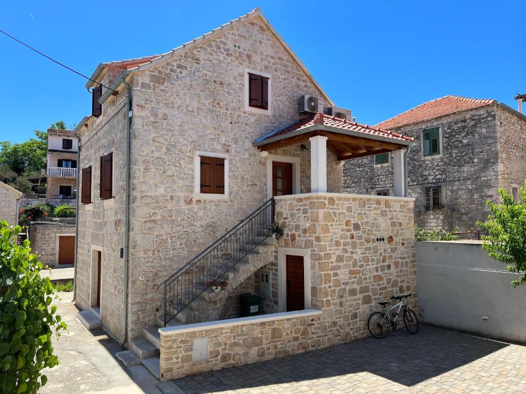 a brick building with a staircase in front of it at House Morko in Vrboska