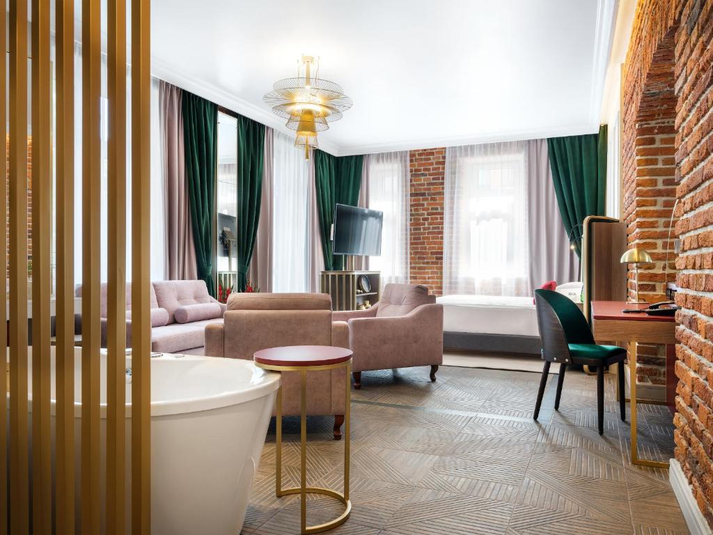 a room with a bath tub and a living room at Golden Queen Aparthotel in Kraków