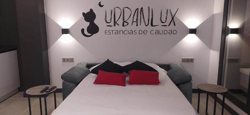 a bedroom with a bed with red and black pillows at Urbanlux Olimpia Familiar in Albacete