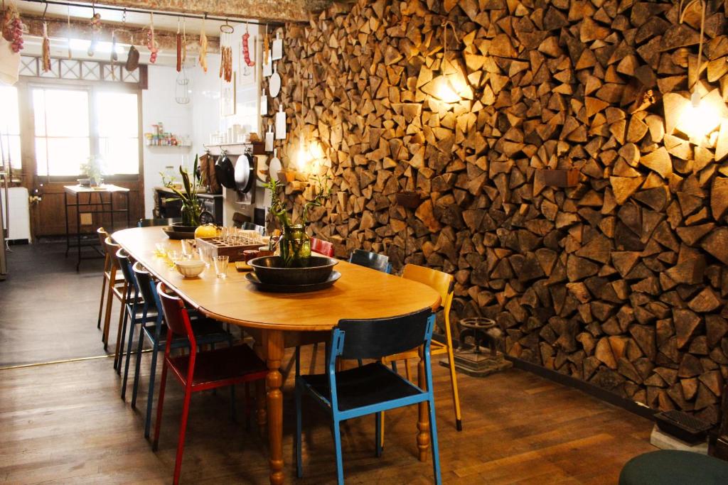 una mesa de madera y sillas en una habitación con una pared de piedra en Eau Berges, en Vicdessos