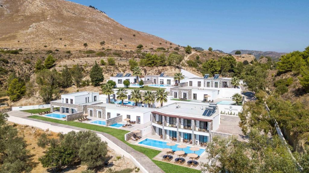 an aerial view of a mansion with a mountain at Terra Pietra Luxury Villas & Suites in Lartos