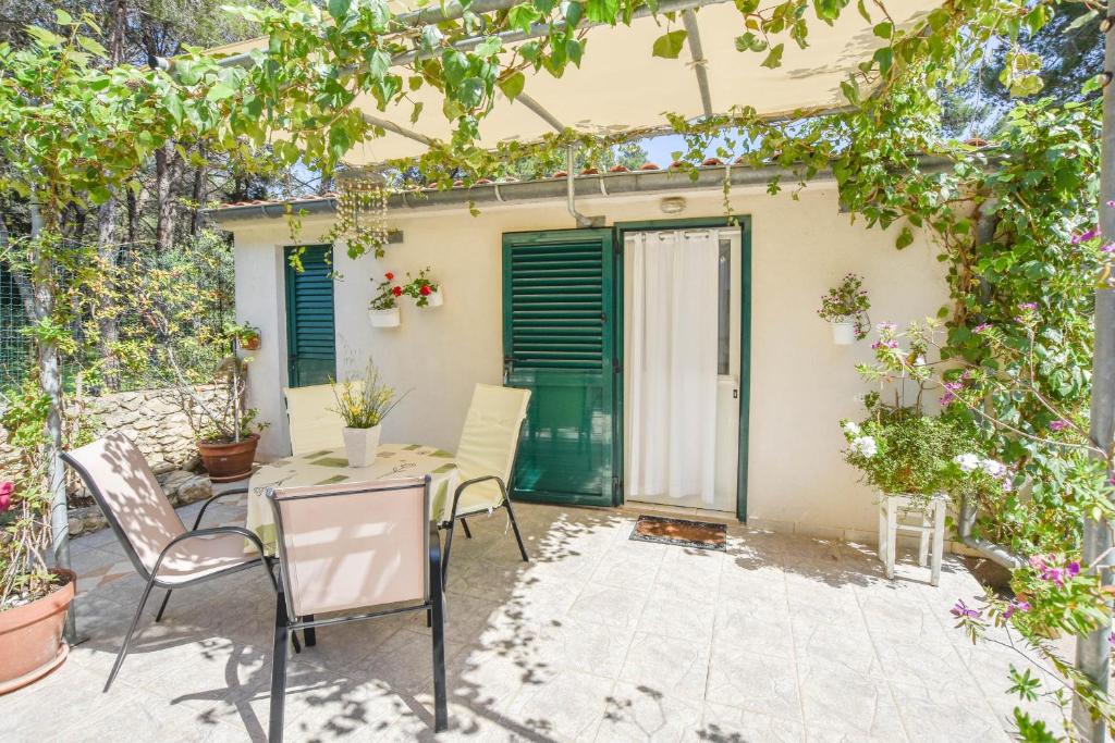 a patio with a table and chairs in front of a house at Apartment Ivan in Veli Rat