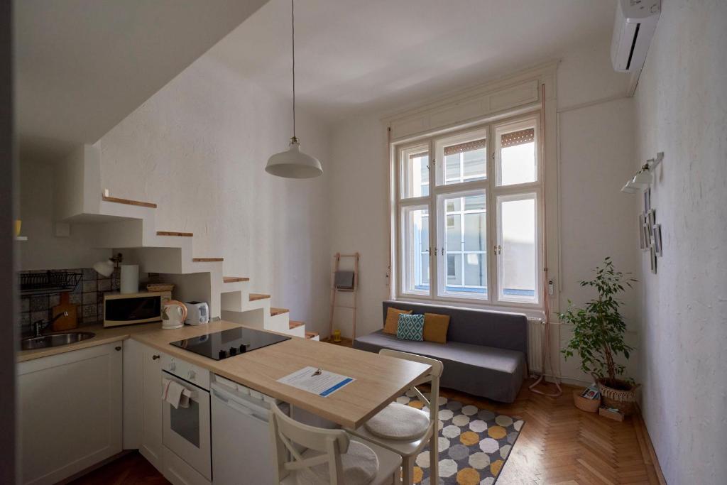 uma cozinha e uma sala de estar com uma mesa em Budapest Downtown W18 em Budapeste