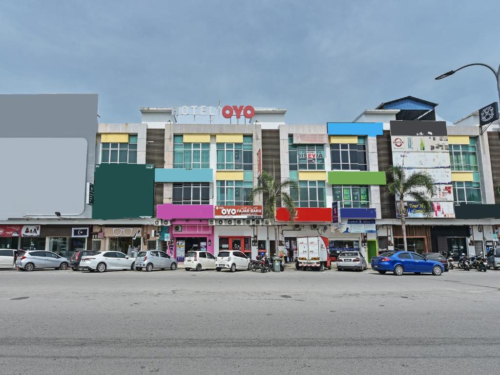 eine Stadtstraße mit Autos, die vor einem Gebäude geparkt sind in der Unterkunft Super OYO 768 Fajar Baru Boutique Hotel in Kuala Terengganu