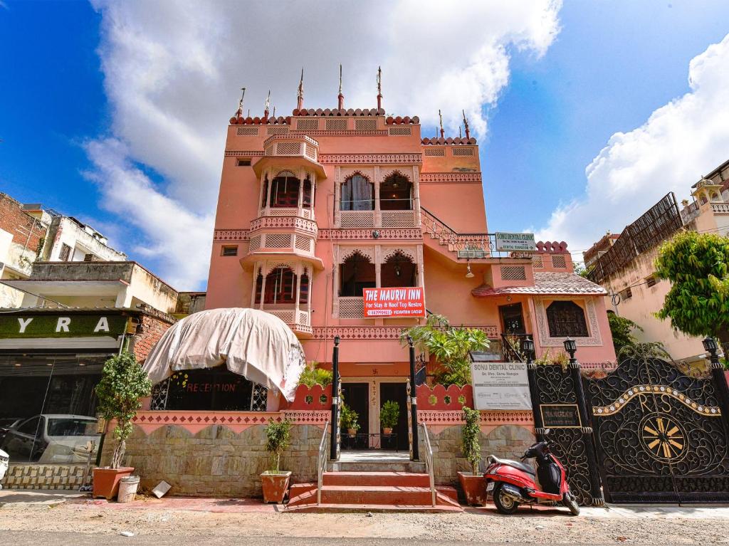 a pink building with a scooter parked in front of it at The Maurvi Inn in Jaipur