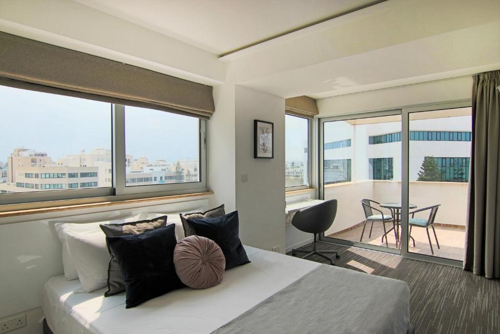 a bedroom with a bed and a balcony with a table at Phaedrus Living: Luxury Suite Nicosia 507 in Nicosia