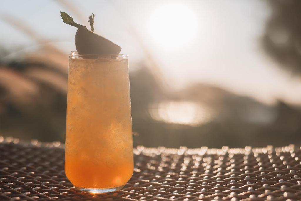 a orange cocktail sitting on a table at The Bay Hotel & Suites in Vasilikos