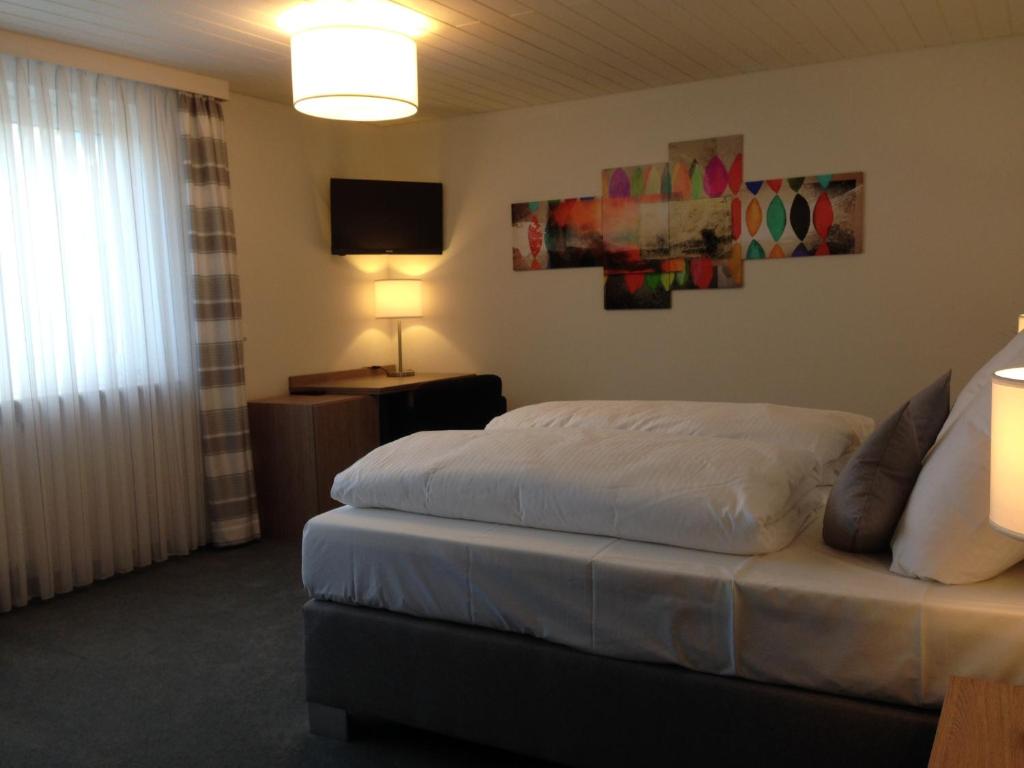 HeroldsbergにあるTankbar's Hotelchenのベッドとテレビが備わるホテルルームです。