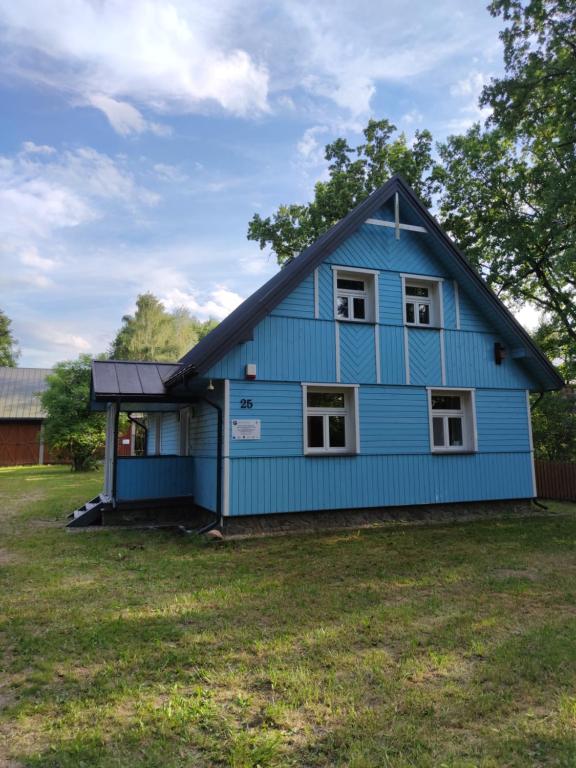 une maison bleue assise au-dessus d'une cour dans l'établissement Kraska Dom Wakacyjny w Sercu Puszczy Białowieskiej, à Białowieża