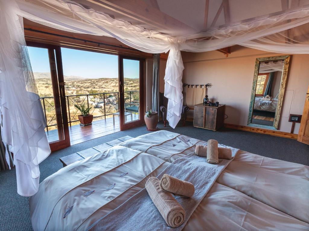 a bedroom with a large bed with towels on it at Ti Melen Boutique Guesthouse in Windhoek