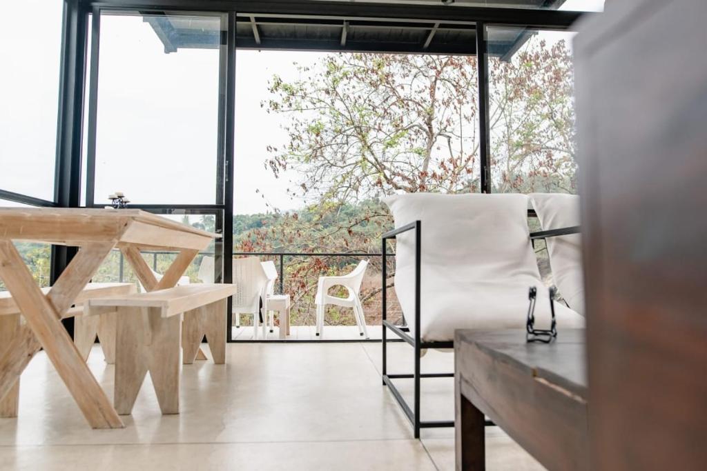 sala de estar con mesa y sillas en el balcón en Casa Del Sol - Luxury Villa 