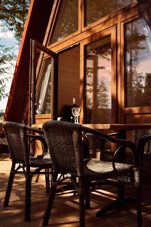 two chairs and a table on the deck of a cabin at Przystań nad Sanem z widokiem na góry i rzekę in Tyrawa Solna