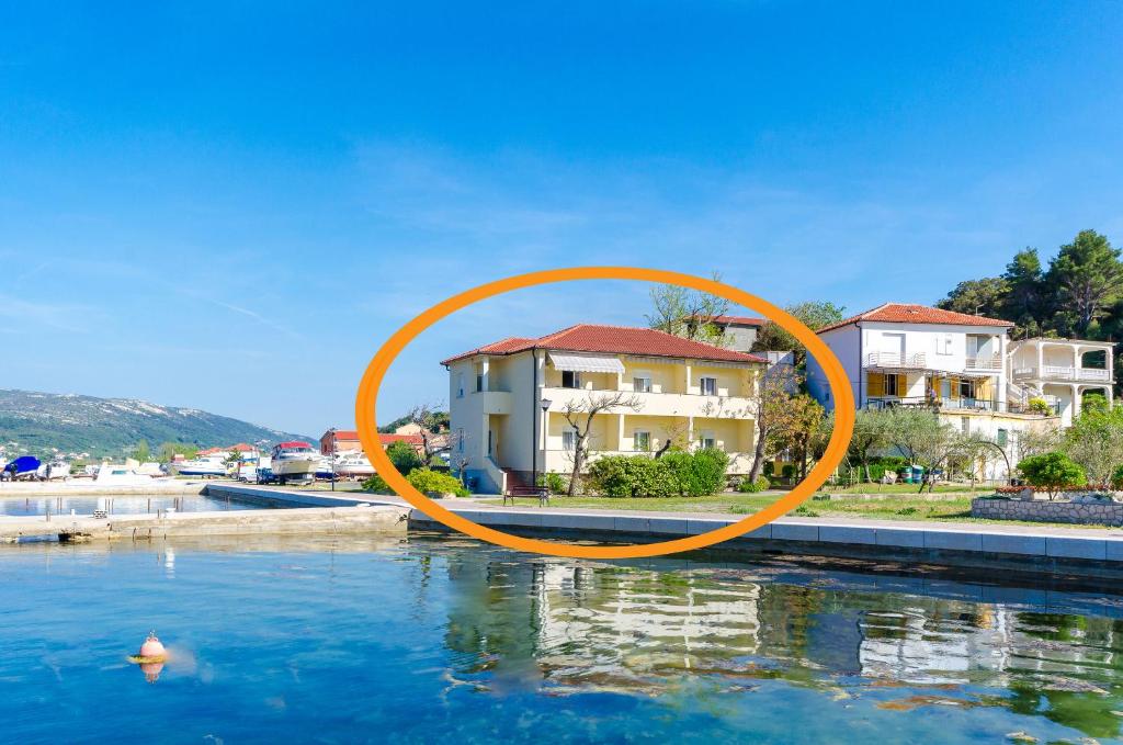 einen orangenen Kreis im Wasser vor einem Haus in der Unterkunft Apartments Darko by the sea in Supetarska Draga