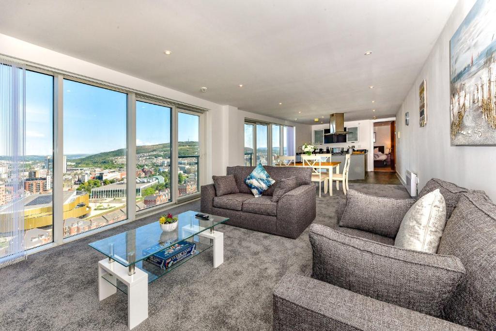 a living room with a couch and a table at Just Stay Wales - Meridian Tower Marina & City View - 2 Bed Apartment in Swansea