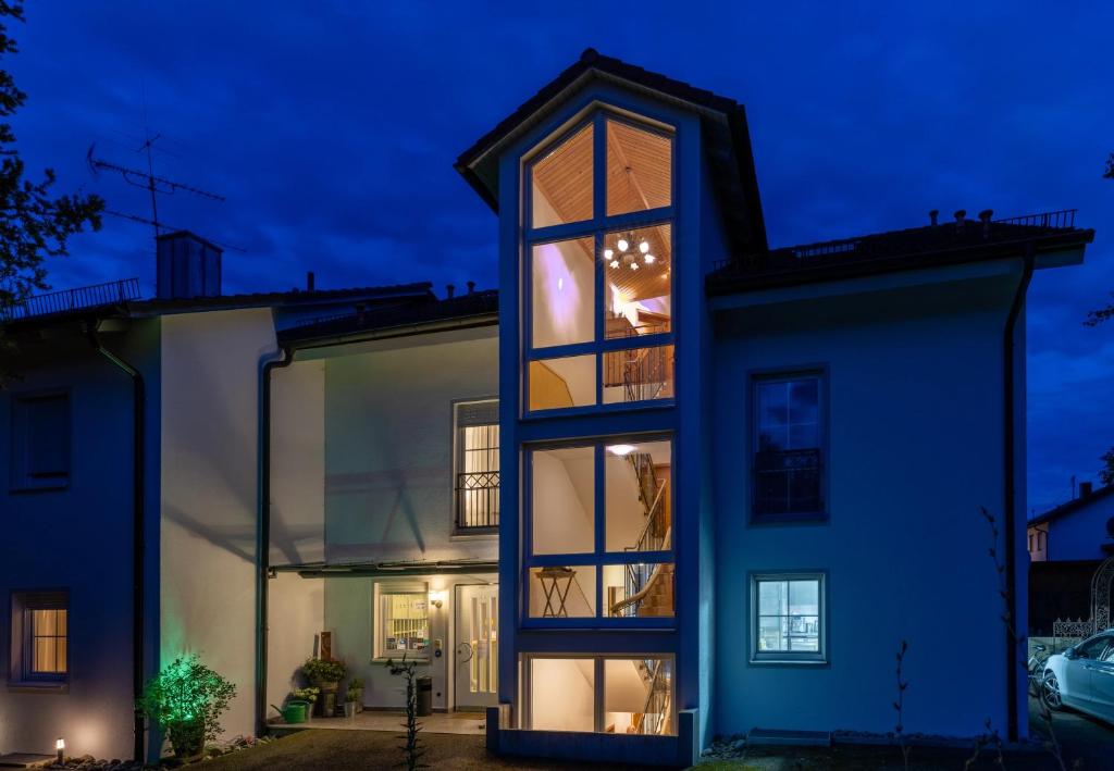 a house with a lit up window at night at Gästehaus Guggenberger in Höhenkirchen-Siegertsbrunn