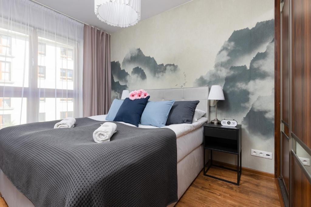 um quarto com uma cama com nuvens pintadas na parede em Warsaw Bemowo Apartment with Balcony by Renters em Varsóvia