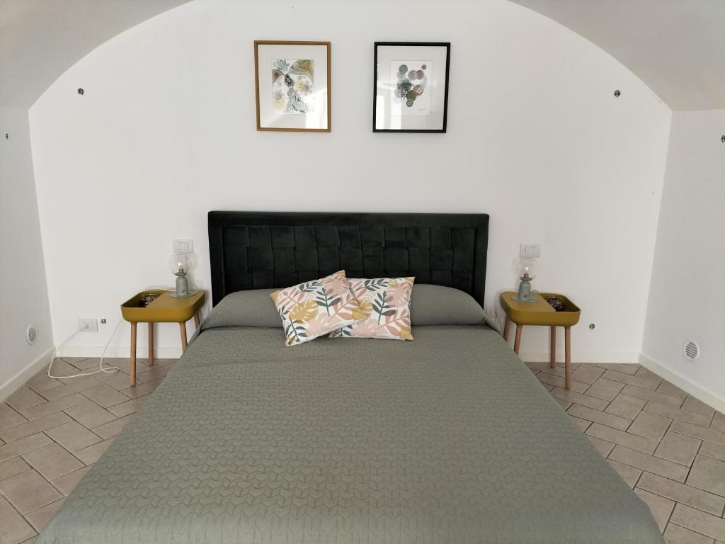um quarto com uma cama grande e duas mesas em Casa Porsia em Altamura