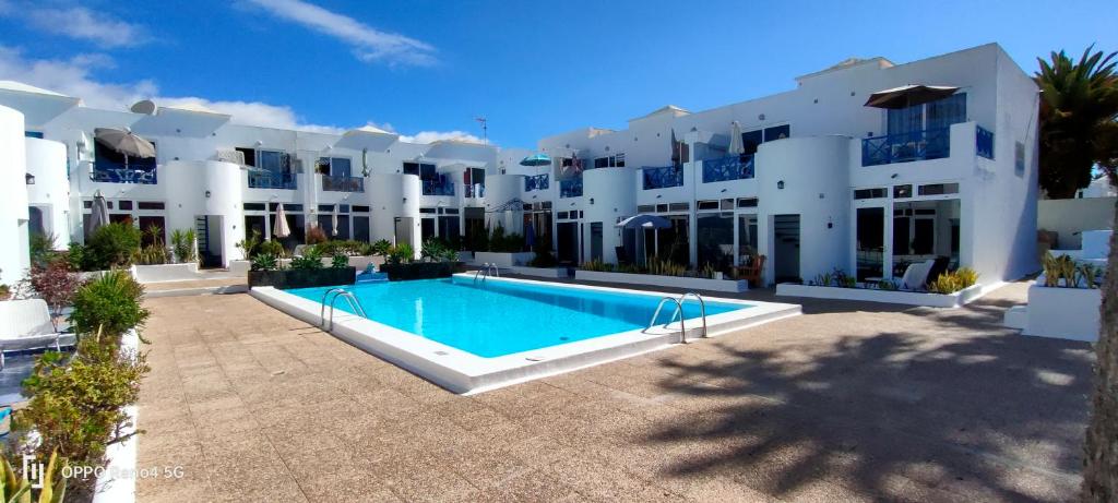 a large white building with a swimming pool in front of it at BLU in Puerto del Carmen