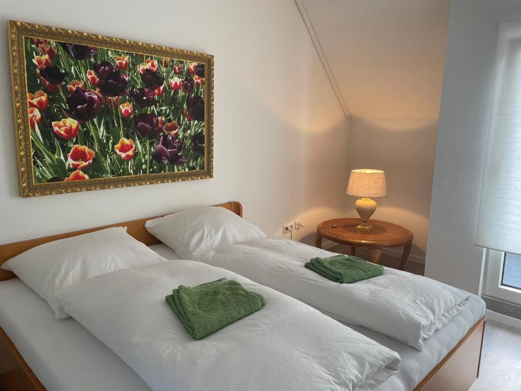 Doppelzimmer في Borgholzhausen: سريرين في غرفة نوم مع لوحة على الحائط