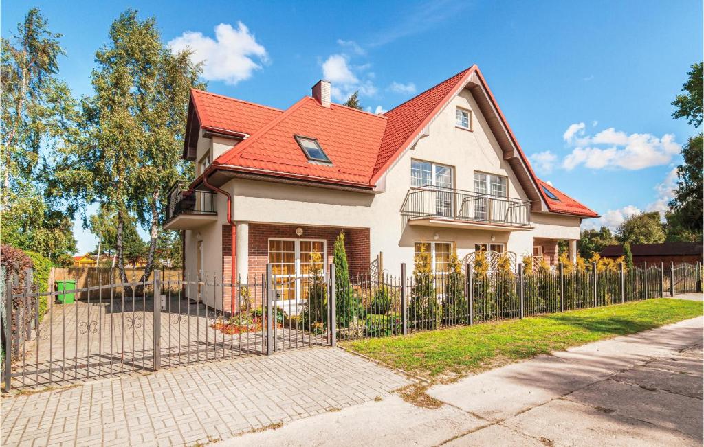 a house with a red roof and a fence at Stunning Apartment In Rowy With Kitchenette in Rowy