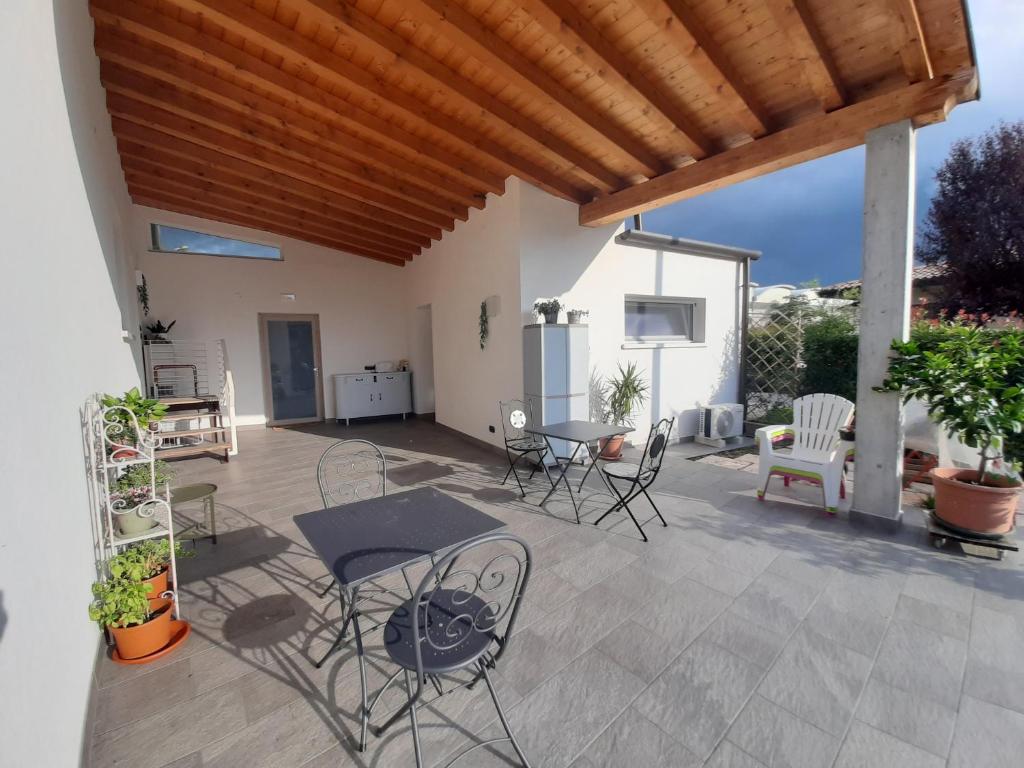 eine Terrasse mit Stühlen, Tischen und einer hölzernen Pergola in der Unterkunft Locazione Turistica El Sghirlo in Vidor