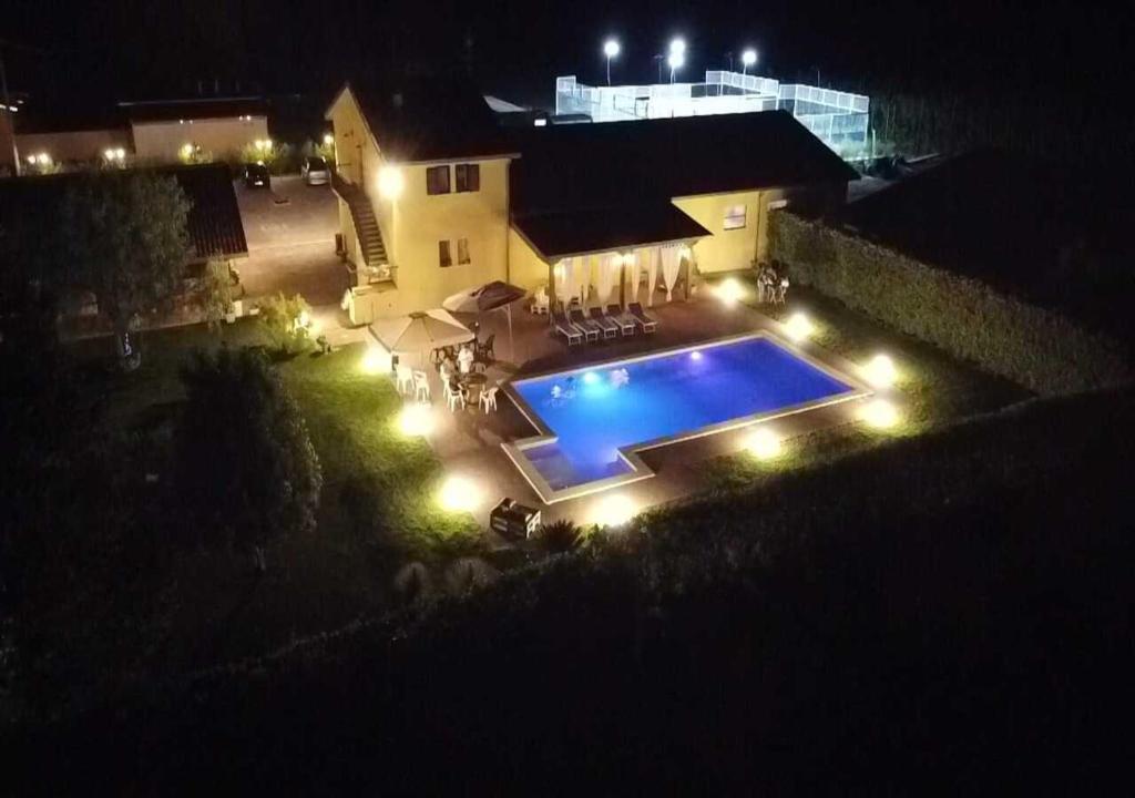 a backyard with a swimming pool at night with lights at Agriturismo Casa Chiara in Latina
