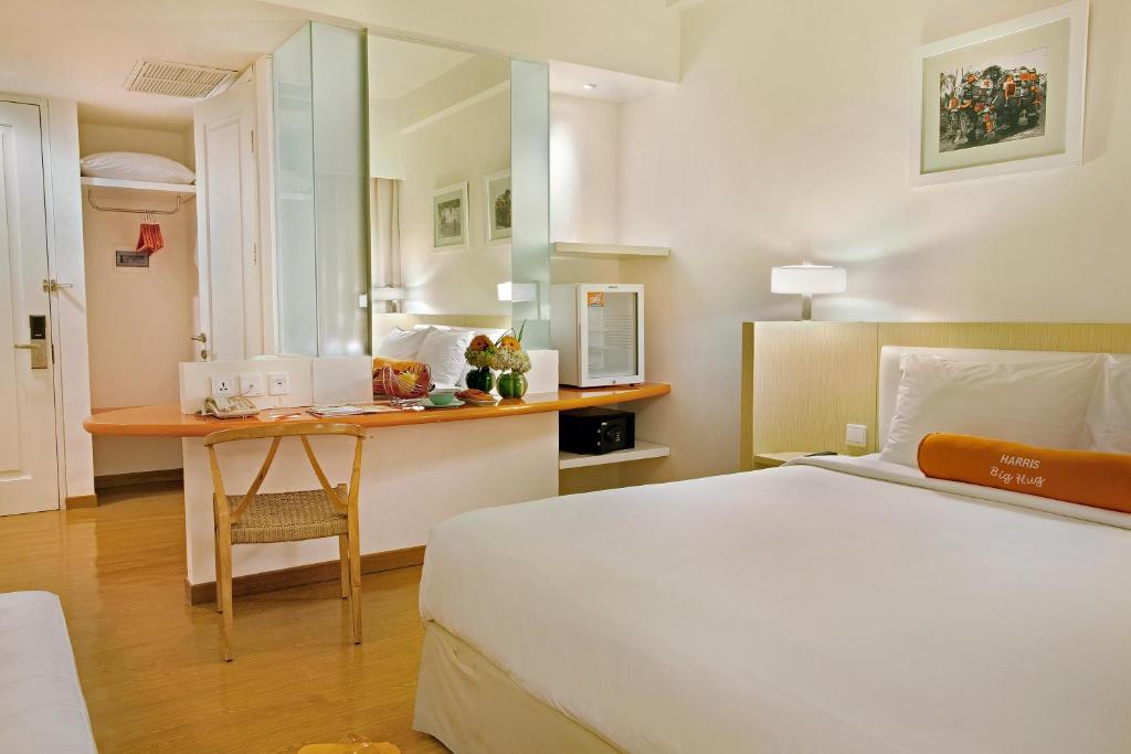 a hotel room with a bed and a desk at HARRIS Hotel & Conventions Malang in Malang