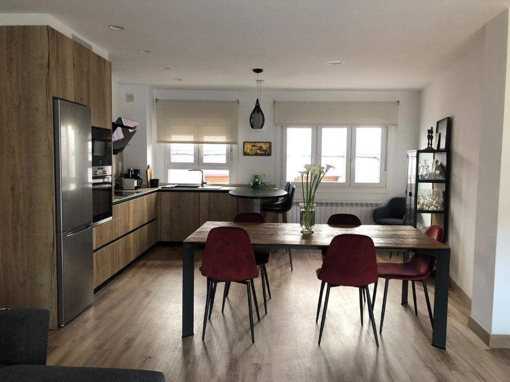 cocina con mesa de madera y sillas rojas en Casa Fitero, en Fitero