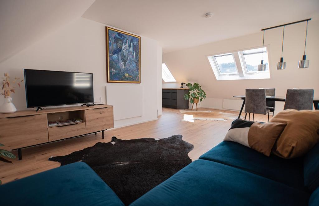 a living room with a blue couch and a tv at ALM-Stube in Füssen