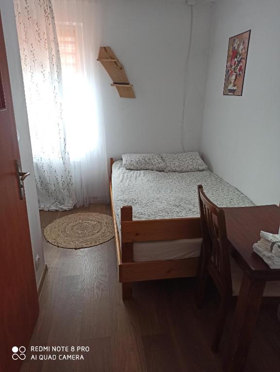 a small bedroom with a bed and a table at Dom Wigierski in Rosochaty Róg