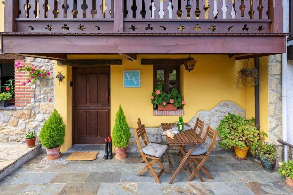 uma mesa e cadeiras em frente a uma casa amarela em Casa Rural Soleada para una Escapada Tranquila em Ceceda de Abajo