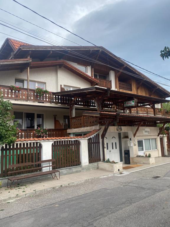 a house with a fence and a bench in front of it at Family Hotel Zdravets in Sofia