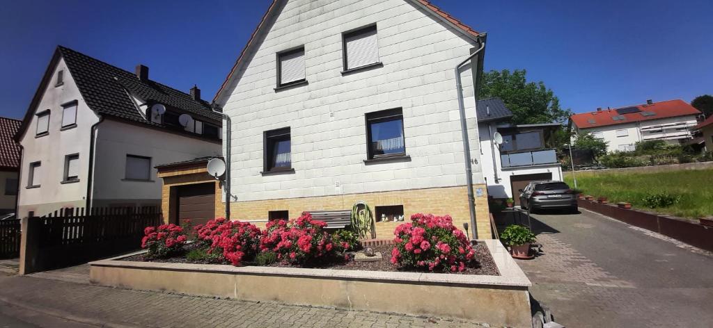 uma casa branca com flores à frente em Ferienwohnung Unterm Schloss bei Inge em Reichelsheim