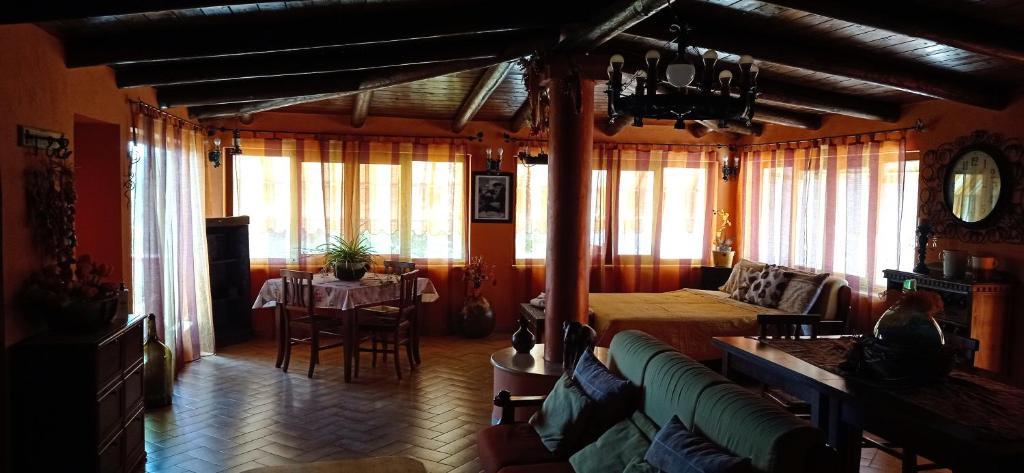 ein Wohnzimmer mit einem Bett, einem Tisch und Stühlen in der Unterkunft Chalet Rustico in Sessa Aurunca