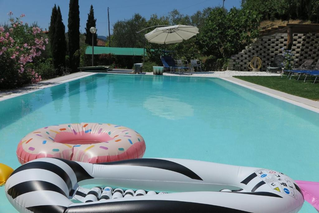una piscina con 2 sillas y una sombrilla en BANKS 1, en Vezzano Ligure