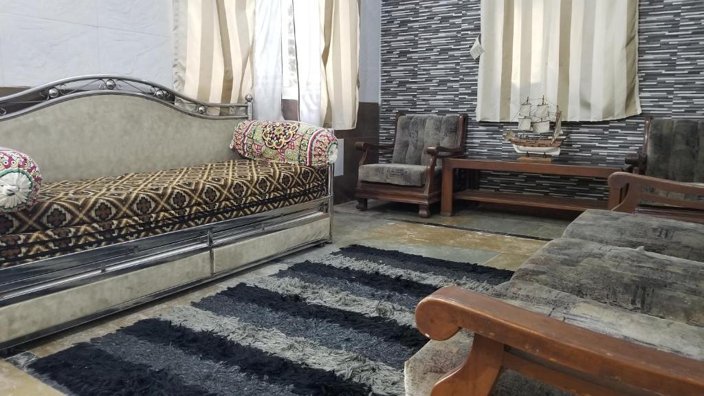 - un salon avec un canapé et une chaise dans l'établissement Tabletop Villa 1 BHK, à Panchgani