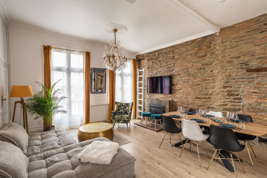 - un salon avec un mur en briques dans l'établissement LE SAINT LOUIS - Apt 3 chambres au cœur de Rennes, à Rennes
