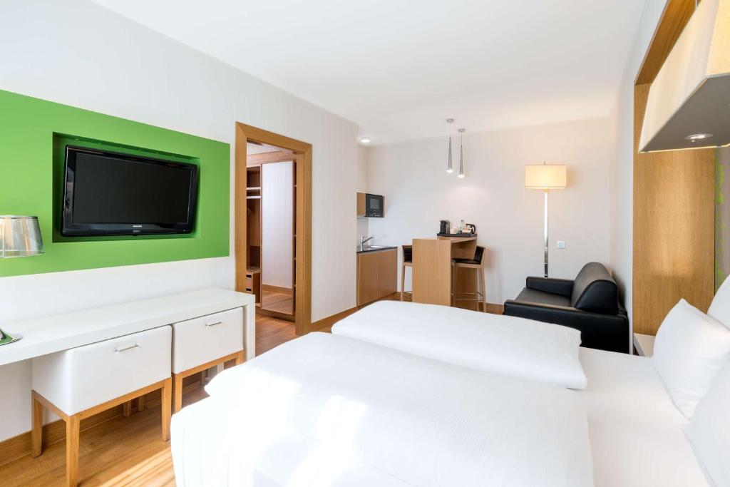 a hotel room with a bed and a tv at NH Frankfurt Messe in Frankfurt