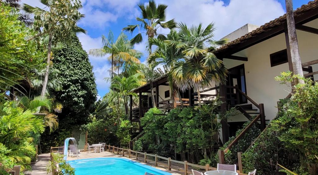 a house with a swimming pool and a resort at Taipabas Hotel in Barra Grande