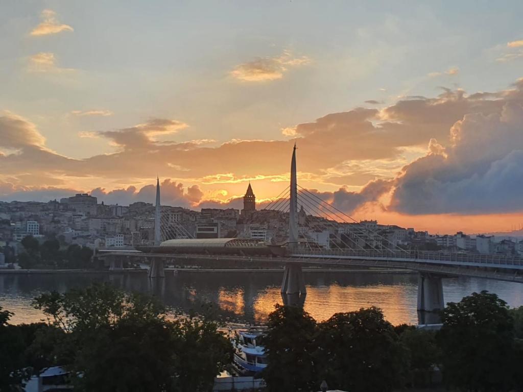 a view of a city with a bridge at sunset at sea star duran apart in Istanbul