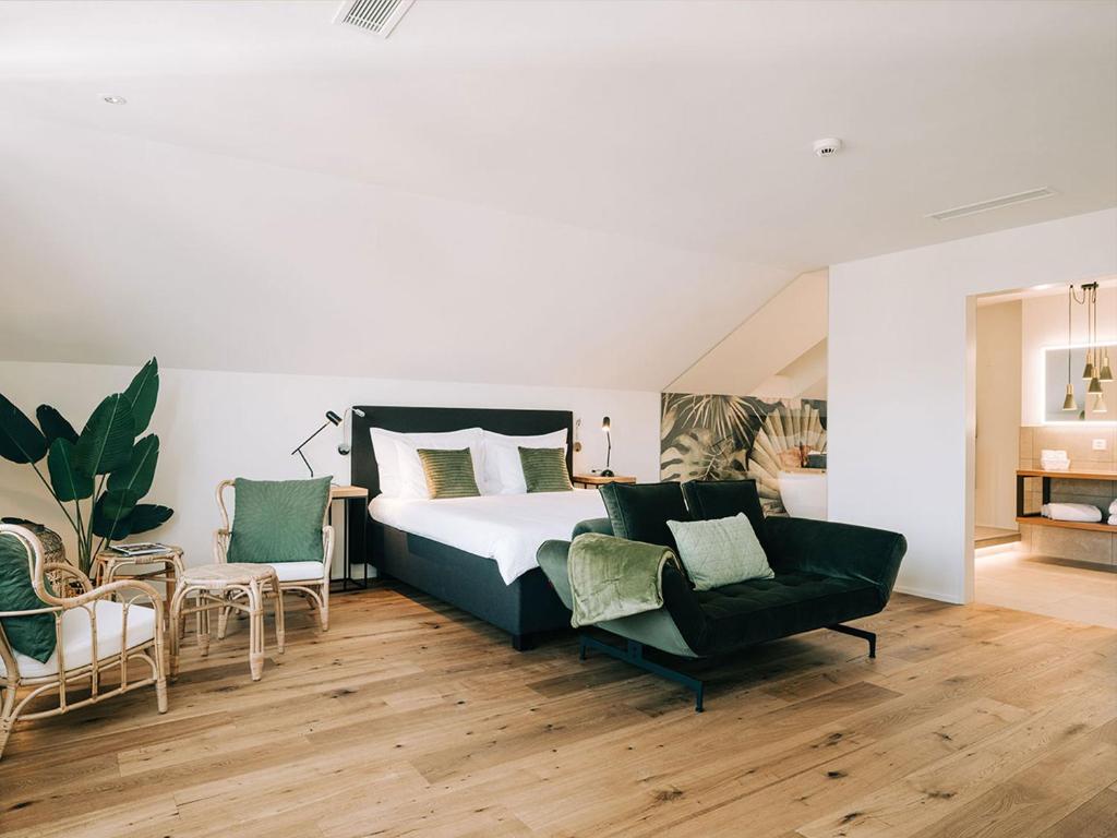 una camera da letto con un letto grande e due sedie di Hotel Krone Thun a Thun