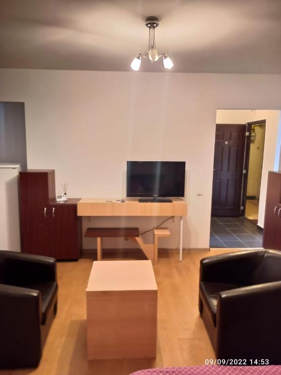 a living room with a desk with a flat screen tv at Central Best cozy in in Bucharest
